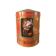 Indlæs billede til gallerivisning Rød kagedåse i form af en spilledåse med julemotive. Her ses julemanden med en dreng
